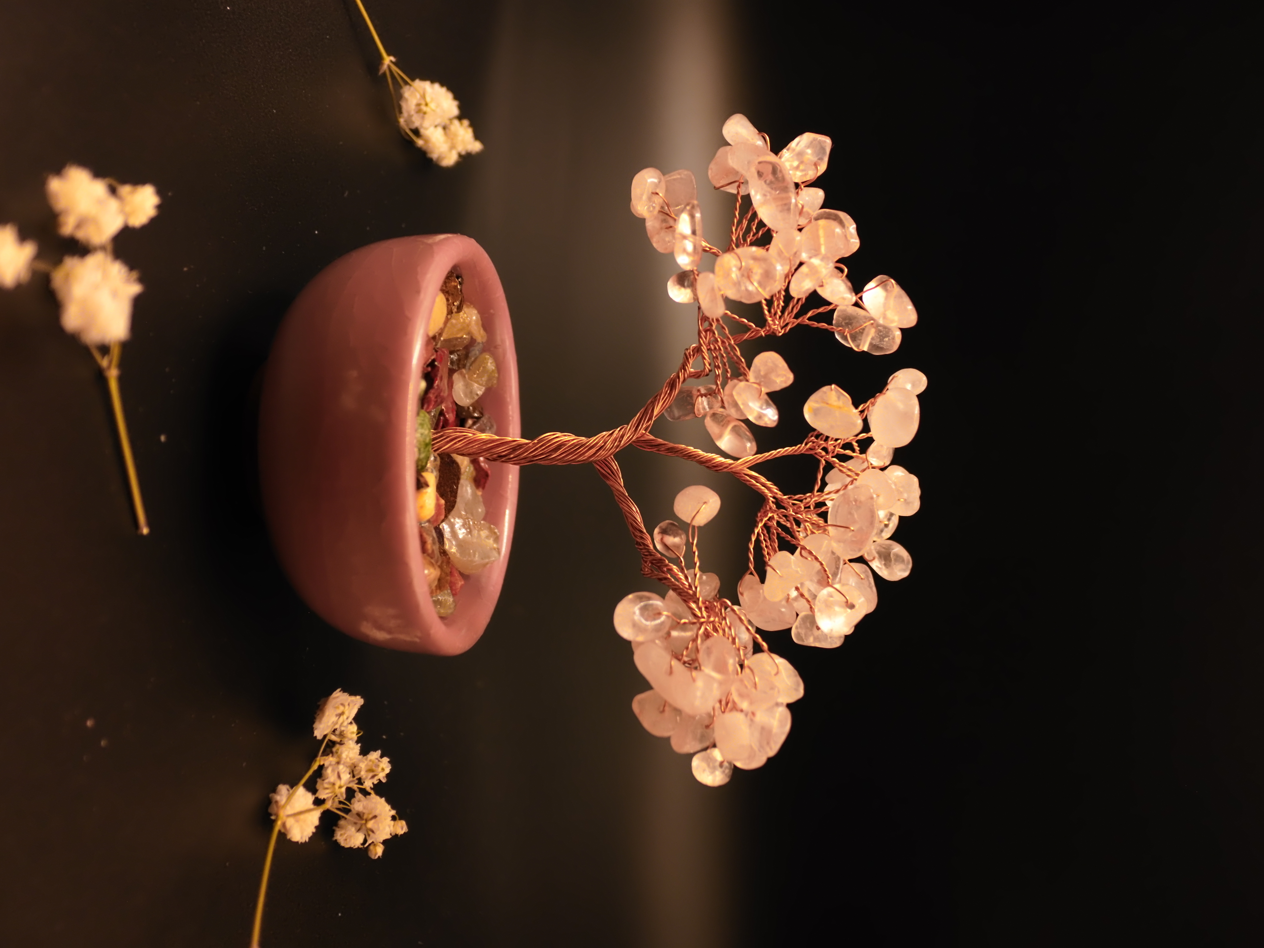 Rose quartz crystal bonsai tree in blush pink ceramic bowl filled with colorful crystal gravel